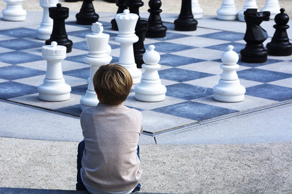 チェス盤を見て考える少年